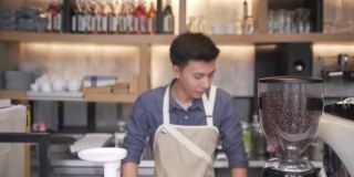 特写和焦点正面:年轻的亚洲咖啡师正在微笑着成为咖啡店的老板