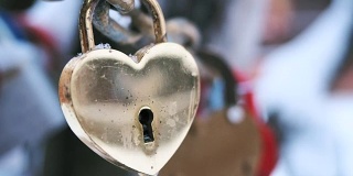 铁链上的金属金锁在冬天的室外随风摇摆。象征爱情和忠贞的婚礼习俗