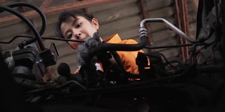 小车低角度视图:亚洲年轻女性汽车技工检查车辆发动机