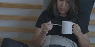 生病的女人在喝热茶。