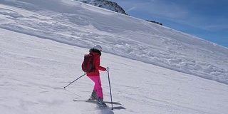 在运动中，女子滑雪者滑雪下山的山坡上