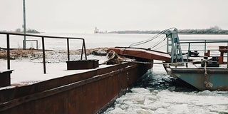 在寒冷的冬天，在结冰的湖面上，生锈的金属码头被雪覆盖