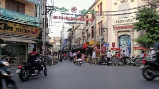 在越南河内繁忙的街道上，摩托车和踏板车经过视频素材模板下载