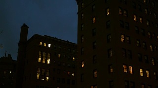 夜间，摄像机拍摄了这座城市的一座砖砌公寓楼视频素材模板下载