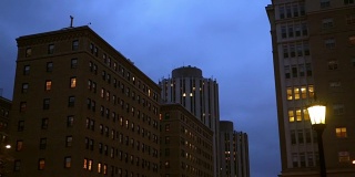 在城市的夜晚，镜头移到普通的砖砌办公大楼