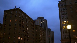在城市的夜晚，镜头移到普通的砖砌办公大楼视频素材模板下载