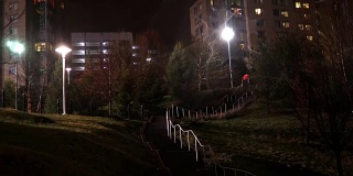 通过混凝土楼梯，穿过昏暗的公园到达公寓大楼