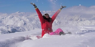 快乐的女人在一个阳光明媚的日子里玩山上的雪，慢镜头，高清。