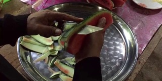 近距离拍摄的女人的手用菜刀切成熟的西瓜新鲜水果