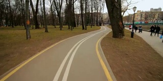 在城市公园的路堤上骑自行车。骑自行车速度