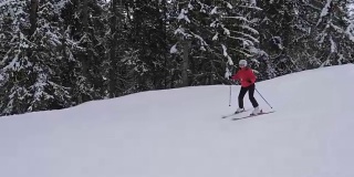 初学滑雪的人小心地用滑雪板滑下山坡