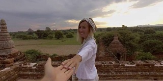 跟我来，一对年轻幸福的夫妇在缅甸古庙上奔跑