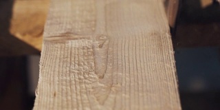 角磨机沿木板一侧滑动，产生大量木屑