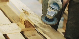 木工人用角磨机打磨木条结构
