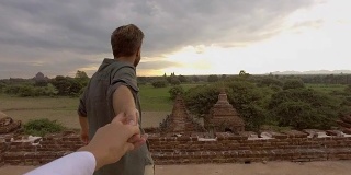 跟我来，一对快乐的年轻夫妇走在缅甸古庙顶上，