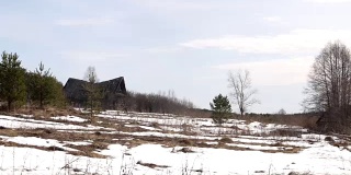 被遗弃和摧毁的俄罗斯村庄小屋分别矗立在雪地里，春天的时候。
