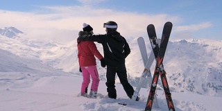 一对相爱的滑雪者在山顶亲吻和拥抱
