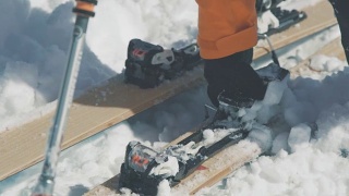 滑雪者的手从滑雪板固定的特写中移除雪视频素材模板下载