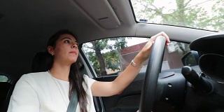 年轻女人开车。低角度拍摄的年轻30岁的女人开车
