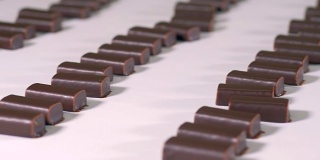 现成的巧克力糖果正在糖果工厂的生产线上移动。