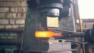 铁匠在铁砧上锻造红热铁——自动锤打视频素材模板下载