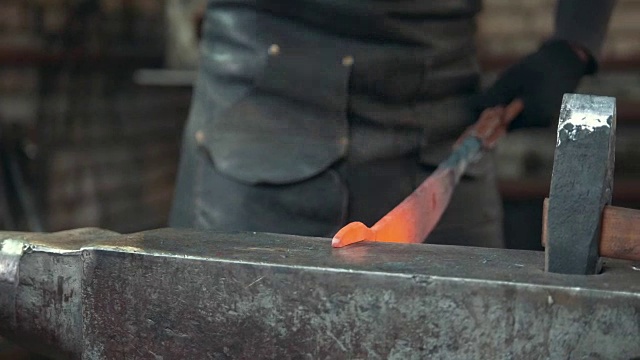 铁匠在铁匠铺手工锻造熔化的金属