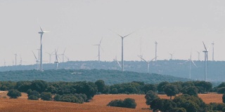 美丽的风车涡轮机在西班牙的田地里利用清洁、绿色的风能。风车发电技术，绿色技术，清洁和可再生能源解决方案