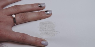 女性的手在纸上涂上铅笔，看起来像比特币