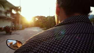 一名男子在热带岛屿上驾驶摩托车，在美丽的日落慢镜头中旅行。泰国。帕,1920 x1080视频素材模板下载