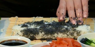 厨师用黑鲟鱼鱼子酱来装饰寿司卷