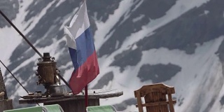 俄罗斯国旗在白雪覆盖的山上飘扬