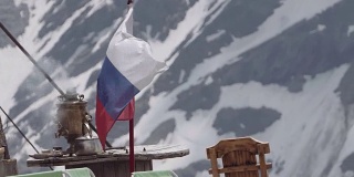 俄罗斯国旗在白雪覆盖的山地营地飘扬