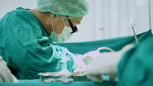 多民族外科手术组穿着防护服在医院手术室进行手术，医疗队在现代手术室进行手术。