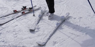 一个滑雪者穿着白色滑雪靴穿上他的下坡滑雪板