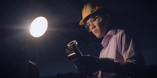 年轻的工厂工程师在工厂的一个工业机器后面操作检查质量