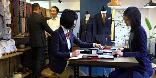 一位高级西服店里的女裁缝正在和一位顾客交谈