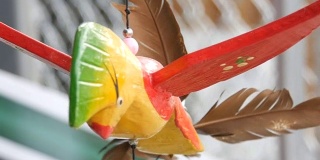 彩色鸟的木制风车运动雕塑在风中发展