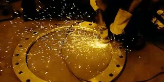 一名工人打磨圆形钢圈的画面