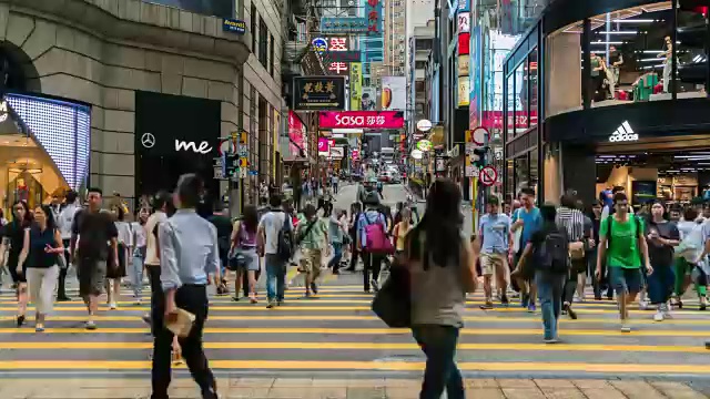 人们在香港商业区的街道上过马路。