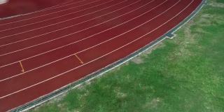 体育场的跑道，颜色是橙色的砖，高角度的无人机观看。