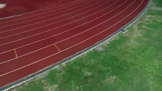 体育场的跑道，颜色是橙色的砖，高角度的无人机观看。视频素材模板下载