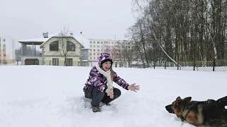 迷人的女人在冬天的衣服拥抱她心爱的狗。视频素材模板下载