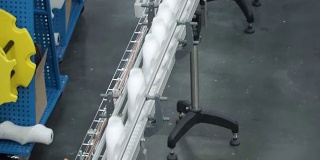 工厂和研究的概念。夹。在生产设备上放置有白色物质的瓶子将被扭曲。瓶子在传送带上排成一行。生产过程