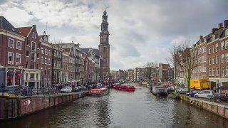 阿姆斯特丹运河，北荷兰，荷兰王国。国家博物馆的塔景。街道和阿姆斯特丹运河，自行车和自行车，游艇，生活船。视频素材模板下载