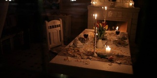 一对恩爱的夫妇在壁炉旁的烛光下进餐