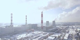 工业景观冒烟的烟囱发电厂在现代城市无人机的观点。从发电厂鸟瞰图上看工业管道排放的烟雾