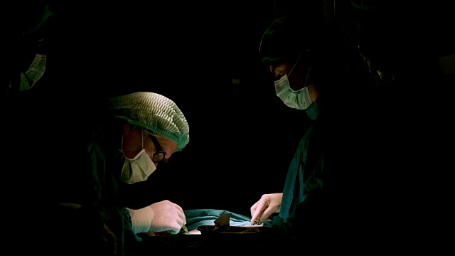 在手术室里给病人做手术的外科医生。