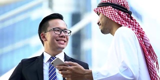 阿拉伯和中国商人在商务会议上讨论。现代城市的背景。国际业务与海外合作。
