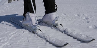 近距离女子滑雪者解开山滑雪靴使用棍棒