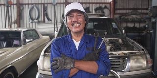 特写摄影:亚洲高级汽车技师微笑着，为这份工作感到自豪